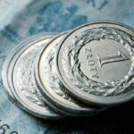 Close-up of Polish zloty coins stacked on a banknote. Financial concept.