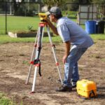 A land surveyor at work using equipment on a field in Tavares, Florida.